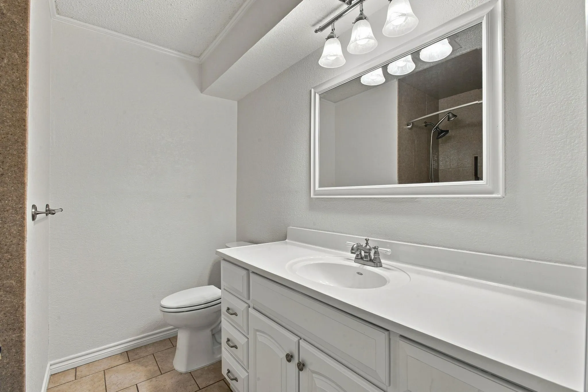 White vanity with overhead lighting, tub and shower