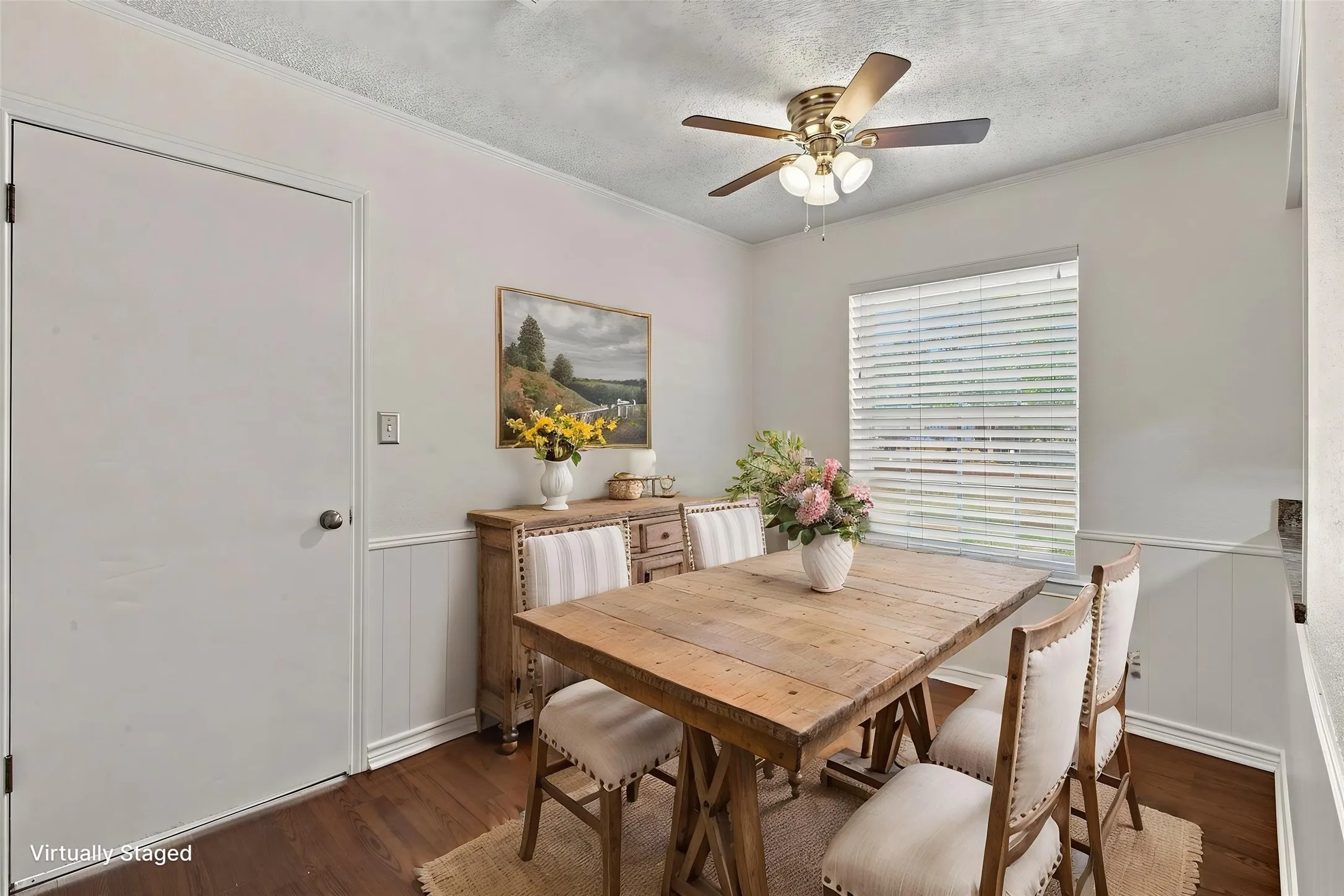 Wood-finish flooring, wainscoting details, ceiling fan with integrated lighting, and window blinds