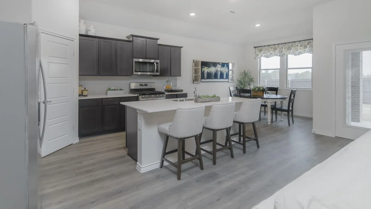 Modern kitchen featuring dark wood-finish cabinetry, stainless steel appliances, a center island with a light-toned countertop, and wood-finish flooring