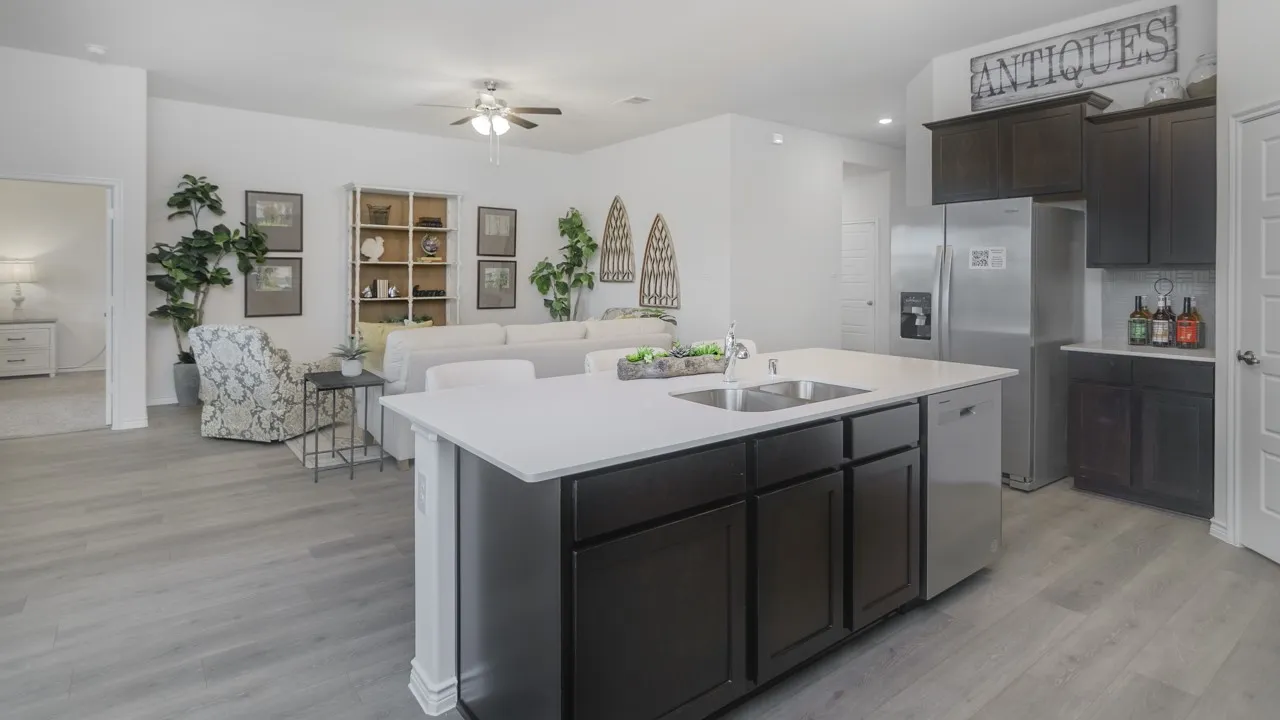 Kitchen island with undermount sink, stainless steel dishwasher, and light-toned countertop