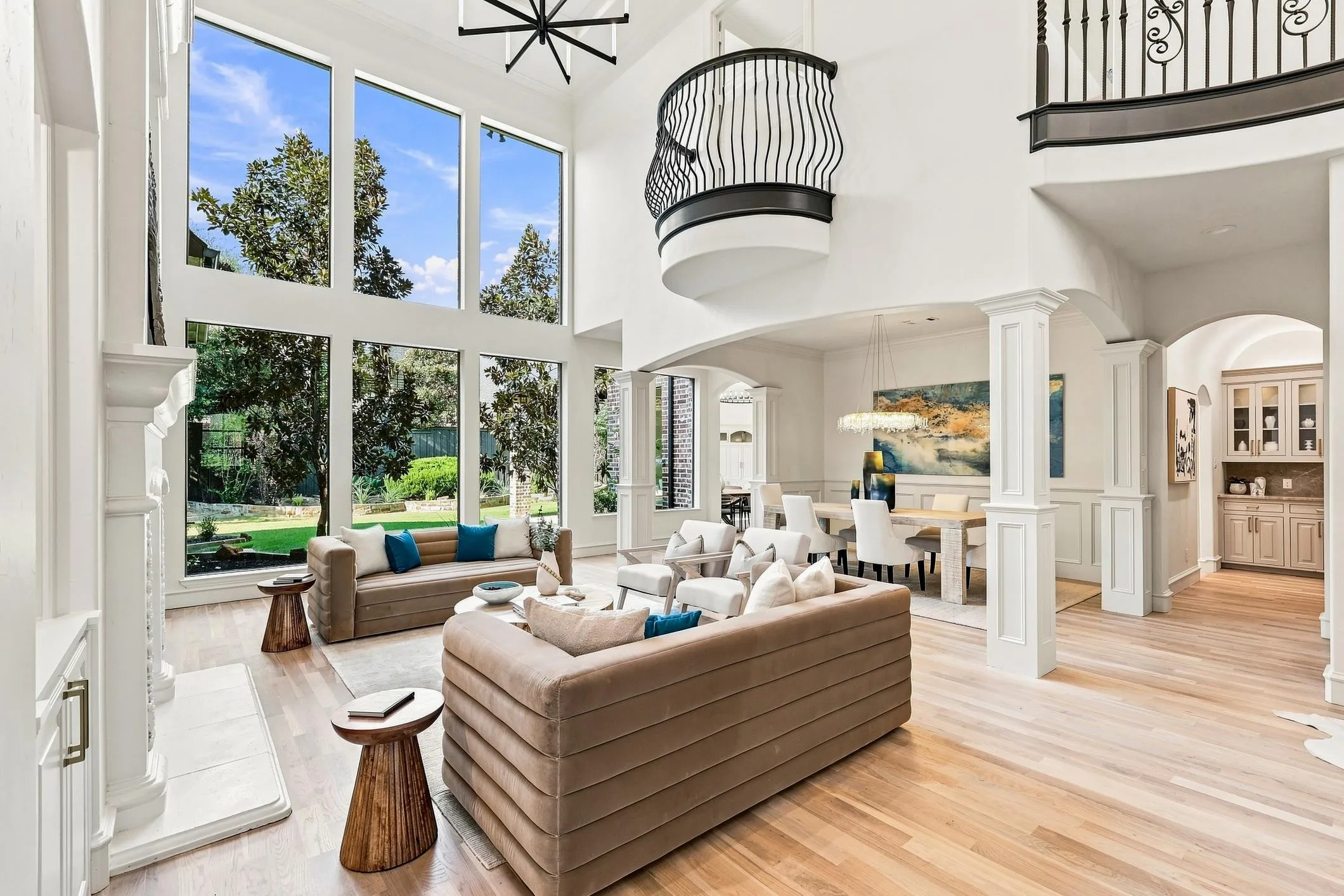 Indescribable views of the backyard area with lots of natural sunlight. Notice the detailed trimwork on columns around dining room, staircase and juliet balcony from the upstairs overlooking downstairs living area