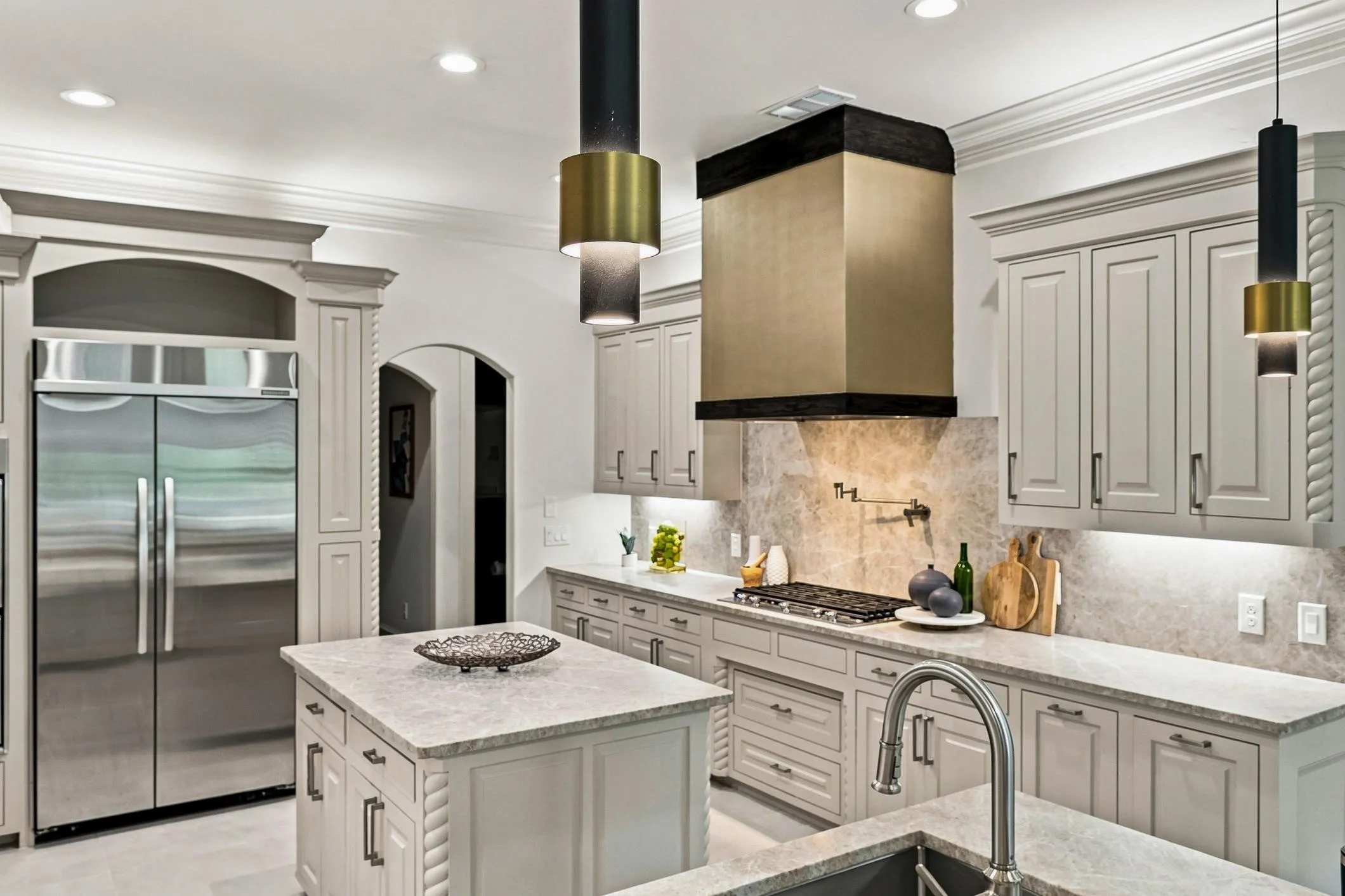 Kitchen featuring island, new quartz counter tops, Porcelain tile flooring and built-in double door refrigerator/freezer and custom pendent lighting.