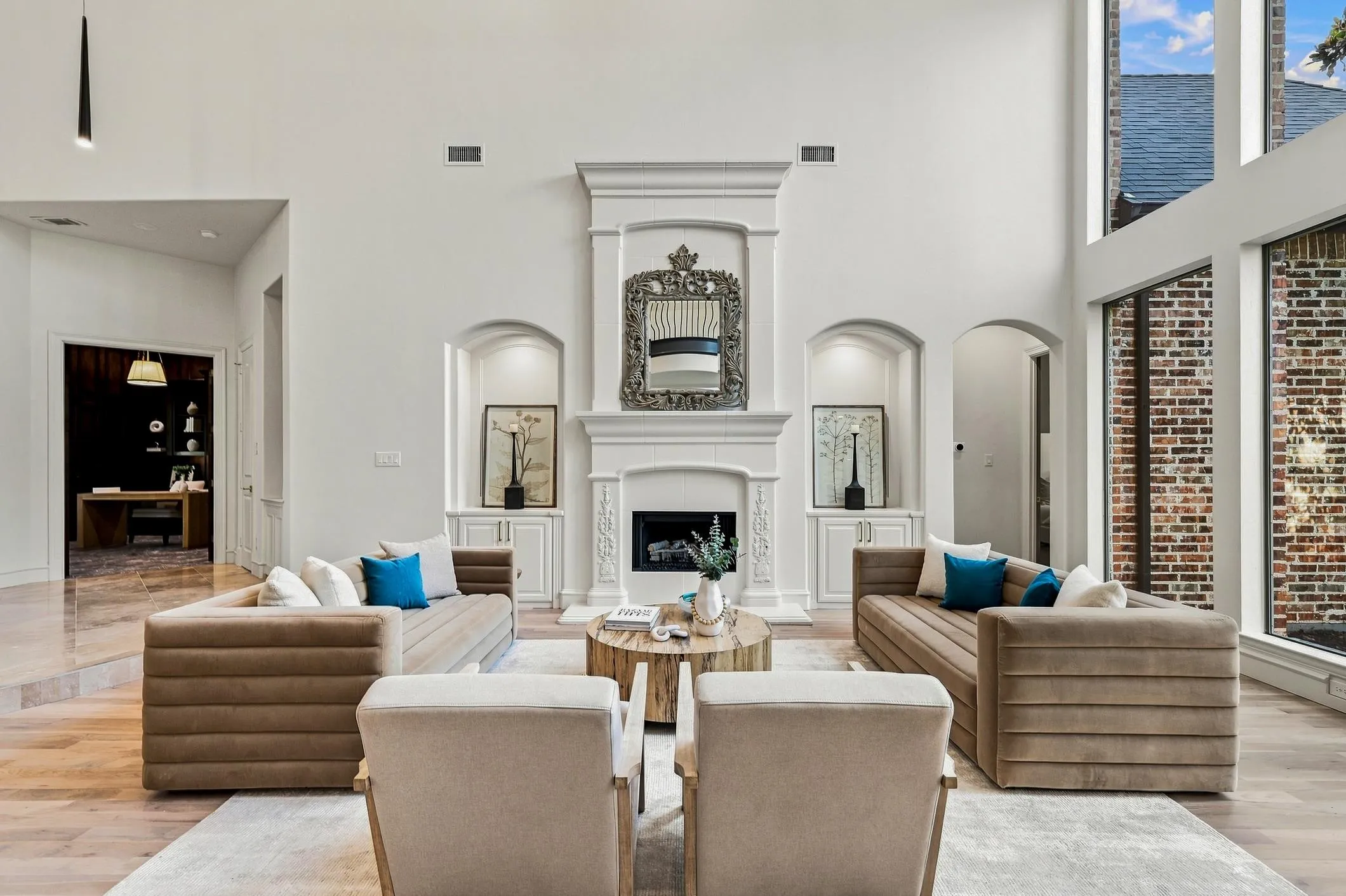 Another view of the seating area around one of the 3 fireplaces in this home. Built-in cabinets, double tier mantel on fireplace with 20 ft. ceilings.