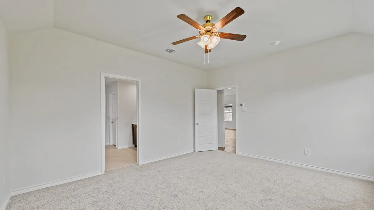 Vaulted ceiling, ceiling fan with integrated lighting, neutral carpet, white walls, and white trim