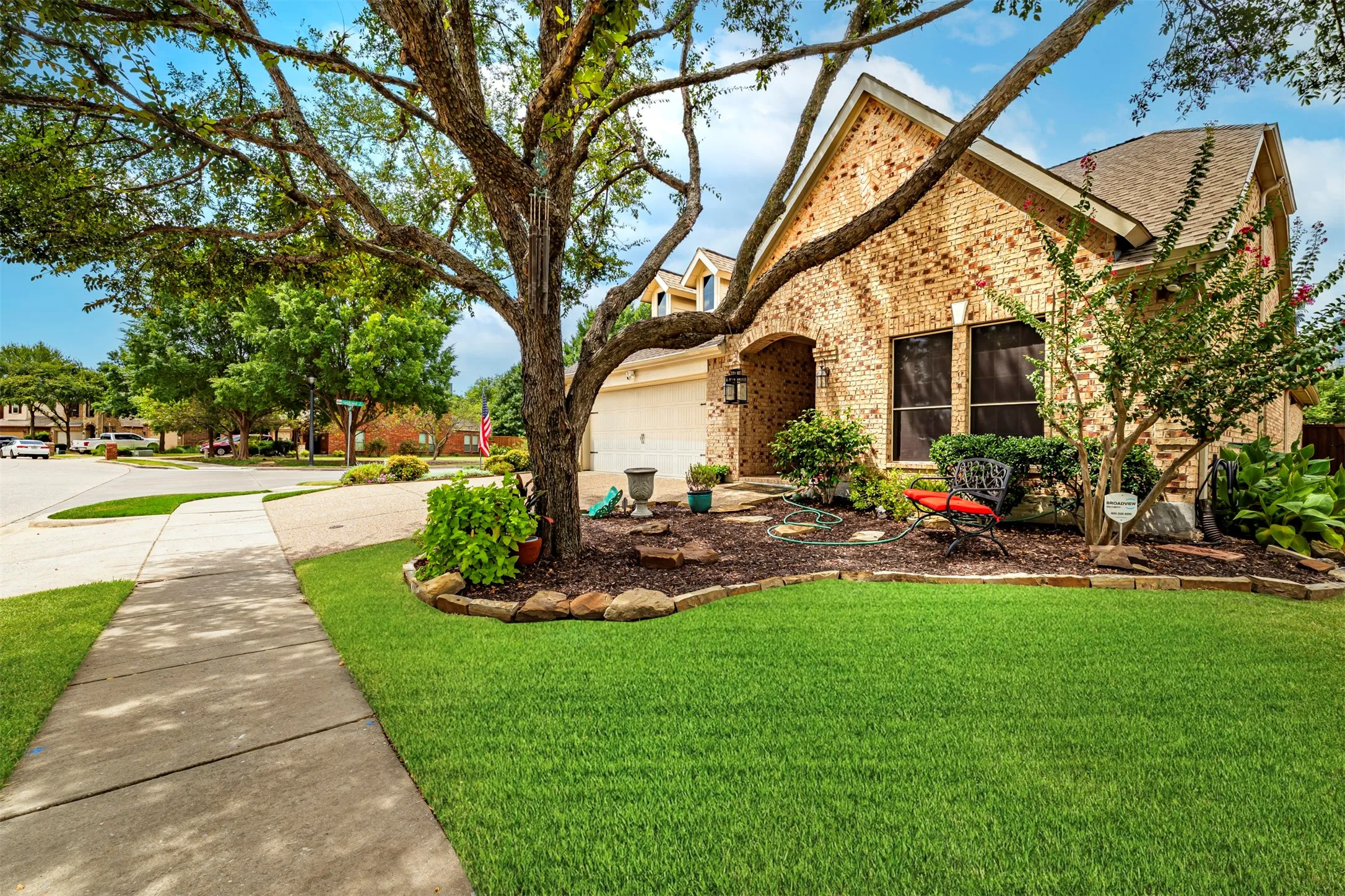 Brick exterior with arched entryway, attached garage, and a gabled roof