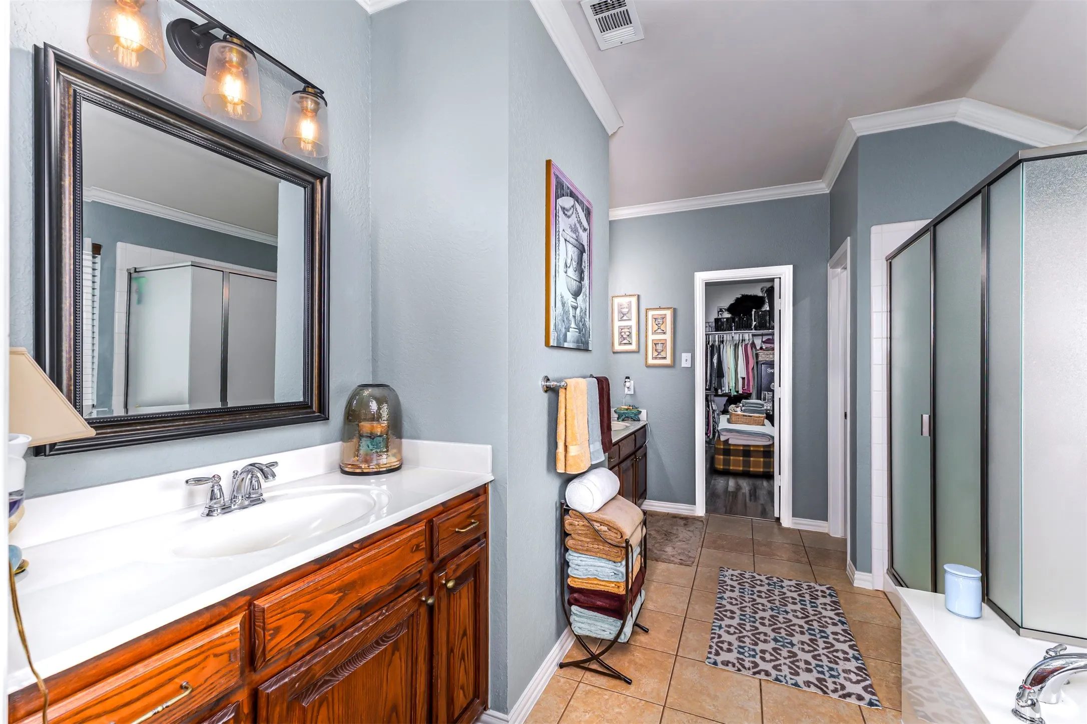 Wood-finish vanity with white countertop, recessed sink, and polished chrome faucet