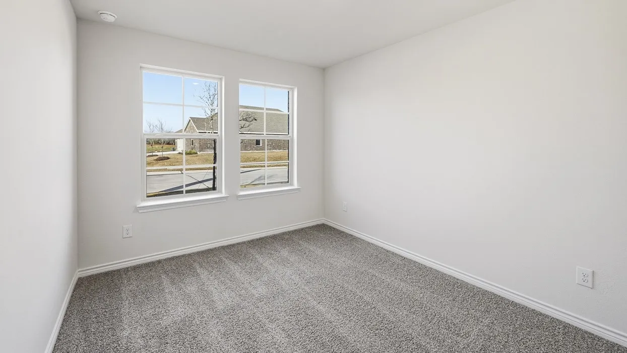 Two large windows, light gray carpeting, and white walls
