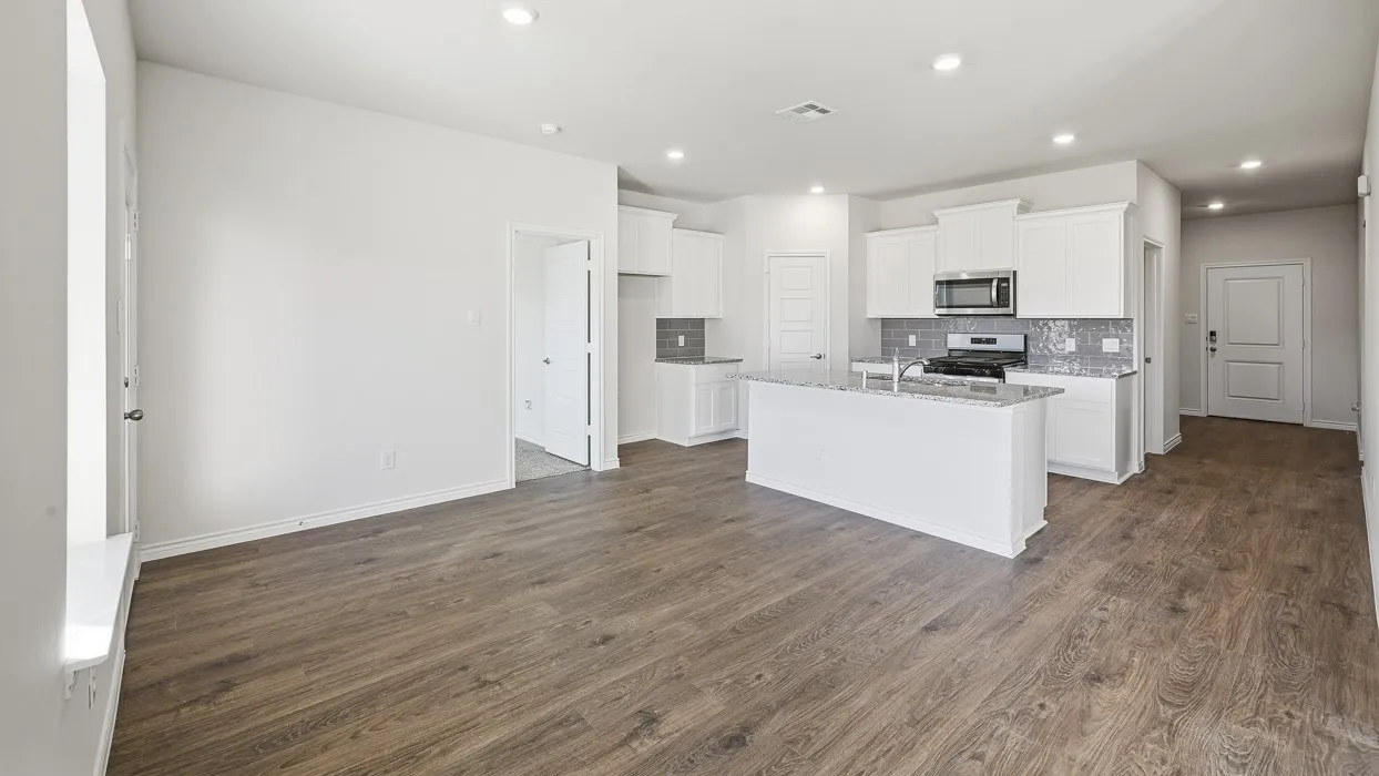 Open-concept living space with wood-finish flooring, recessed lighting, and white walls