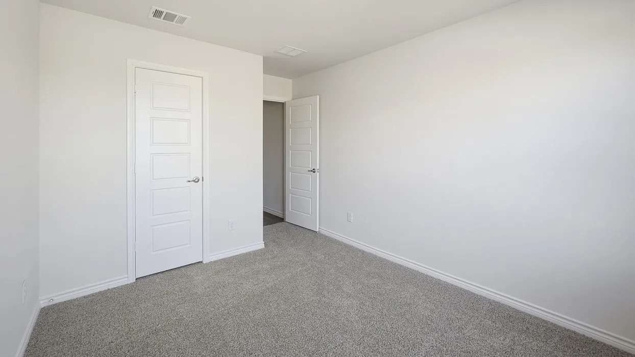 Plush gray carpeting, white painted walls, and white paneled doors with chrome hardware