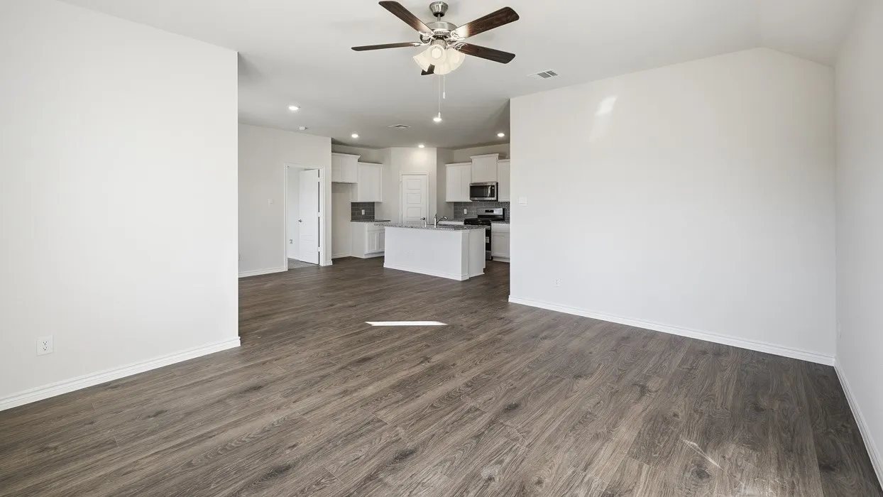 Wood-finish flooring, white painted walls, and a ceiling fan with integrated lighting