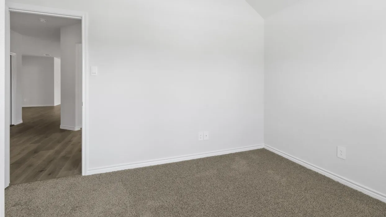 Carpeted flooring, vaulted ceiling, and white wall finishes