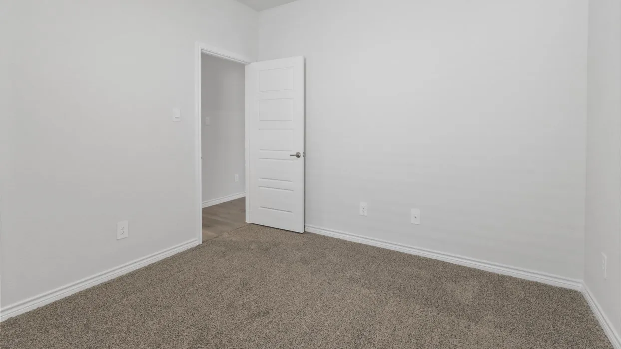 Neutral wall color, carpeted flooring, and a modern interior door with horizontal panels