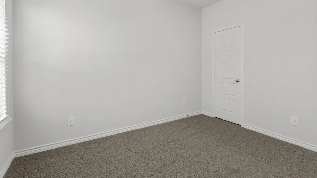 Neutral wall tones, textured carpeting, white trim, and a white paneled door