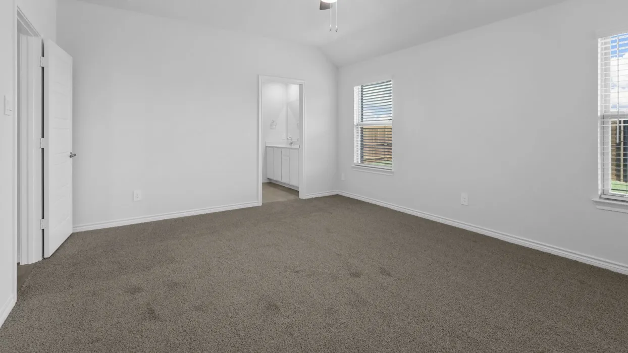 Spacious room featuring vaulted ceilings, neutral-toned carpet, and multiple windows with blinds