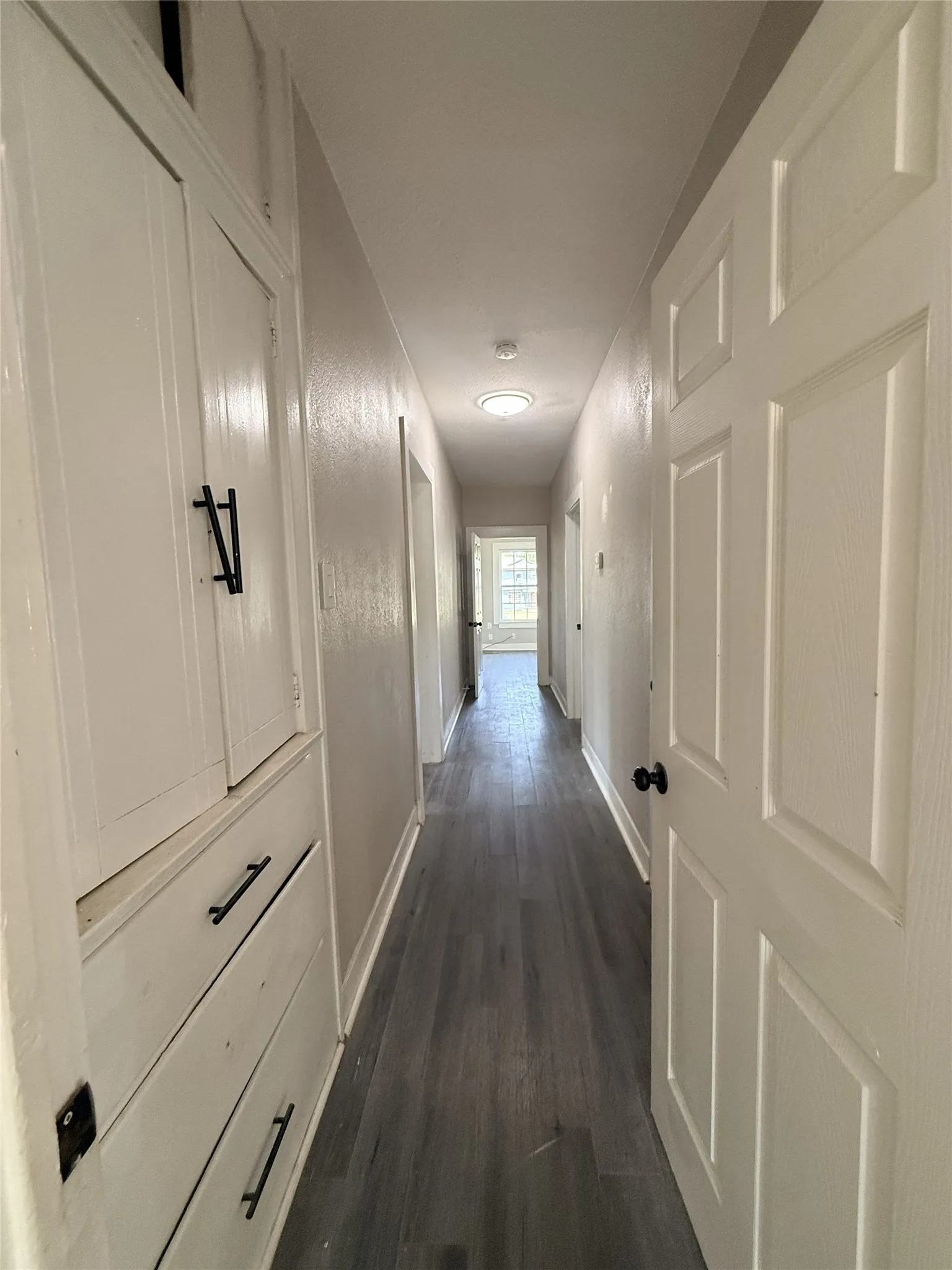 Hallway featuring wood-finish flooring, built-in cabinetry, and recessed lighting