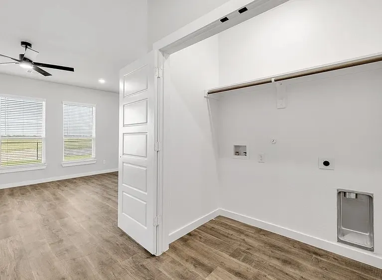 Wood-finish flooring throughout, modern ceiling fan, recessed lighting, and laundry utility connections