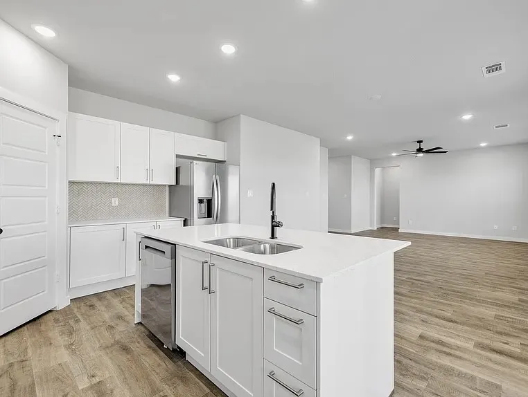 Contemporary kitchen with a central island, white cabinetry, and stainless steel appliances