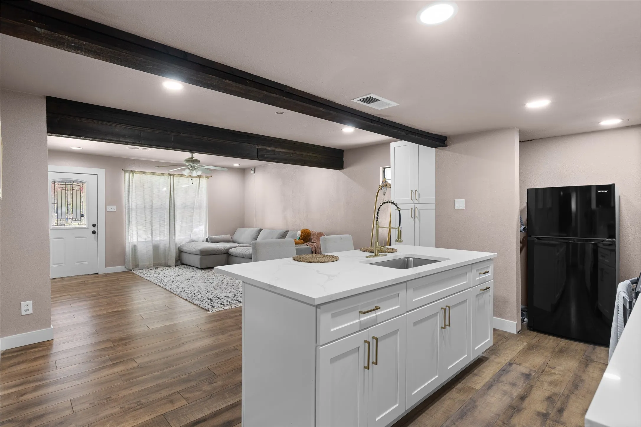 Kitchen island with a built-in sink and gold-finish faucet