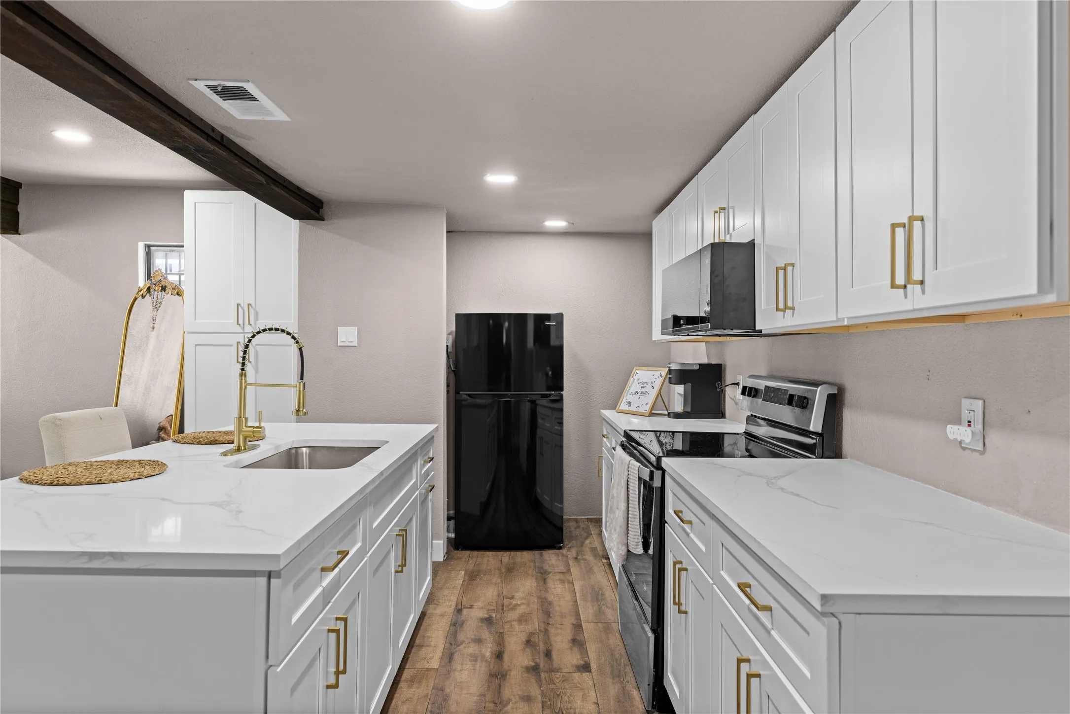 Kitchen featuring white cabinetry, gold-tone hardware, wood-finish flooring, white countertops, and recessed lighting