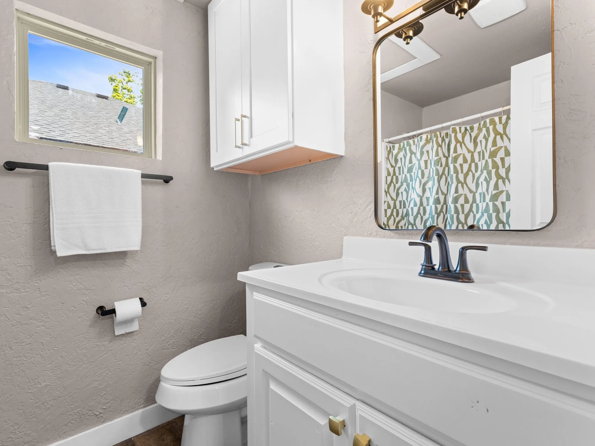 White vanity with an integrated sink and bronze-finish faucet