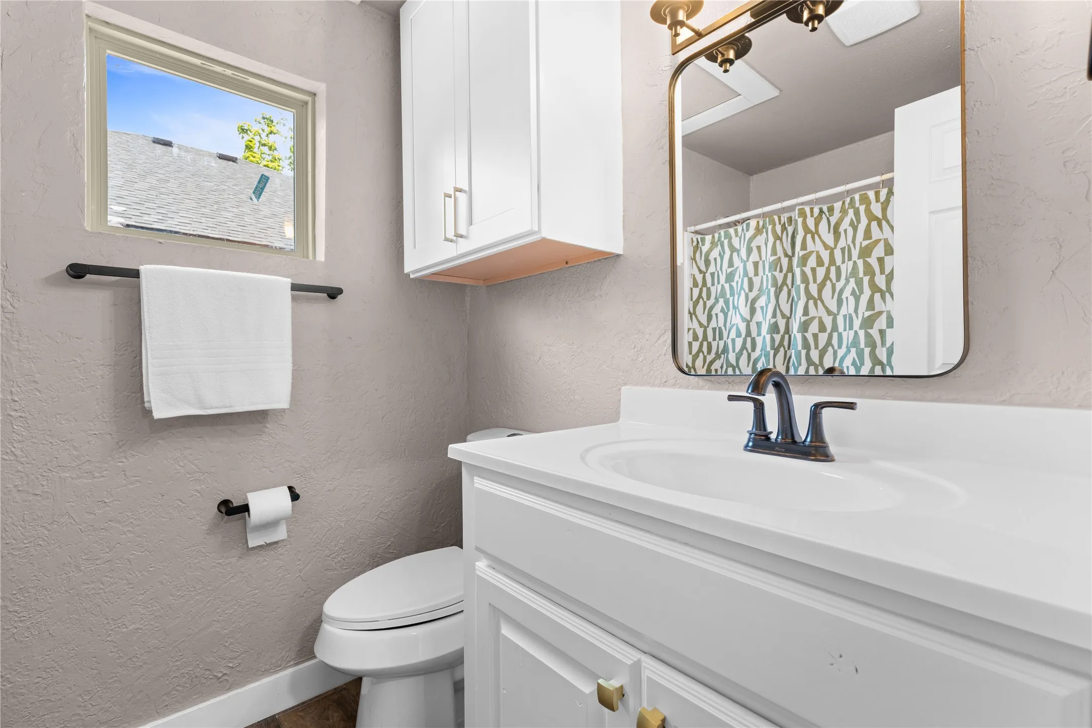 White vanity with an integrated sink and oil-rubbed bronze faucet
