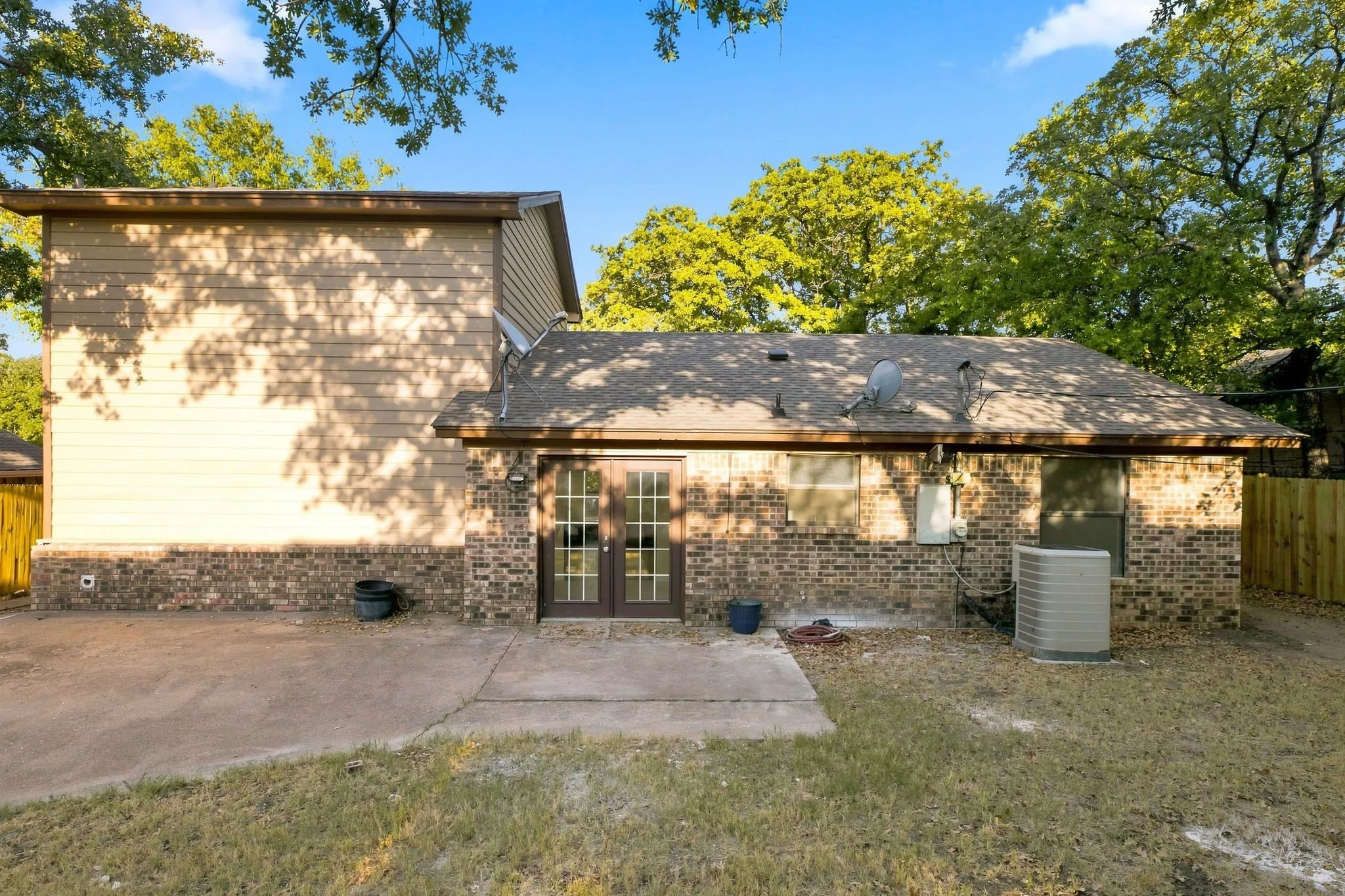 Brick and siding exterior with a patio and a grass yard