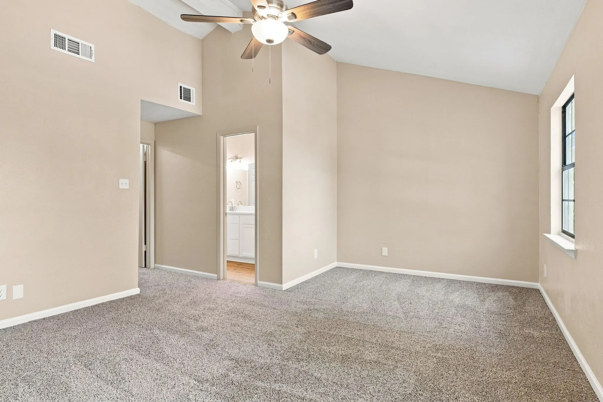 Vaulted ceiling with a wood-finish ceiling fan and attached lighting fixture