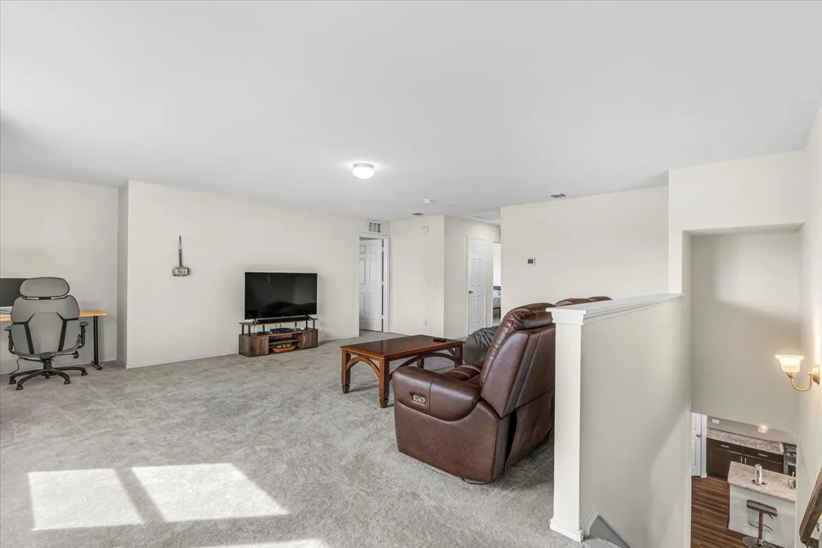 Spacious upper-level area with light gray carpeting