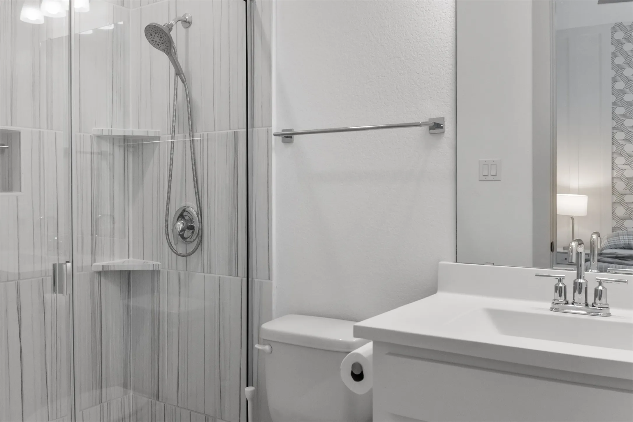 2nd-primary-bed-room's ensuit bath with glass-enclosed shower with tiled walls and built-in shelving