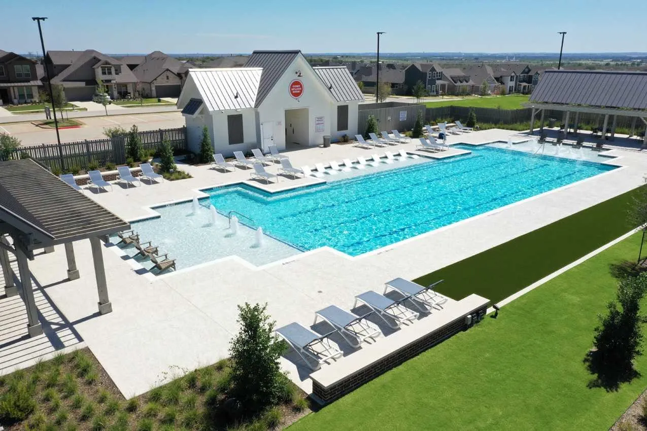 Outdoor swimming pool with integrated fountains, adjacent clubhouse, and shaded​​‌​​​​‌​​‌‌​‌‌​​​‌‌​‌​‌​‌​​​‌​​ pergola