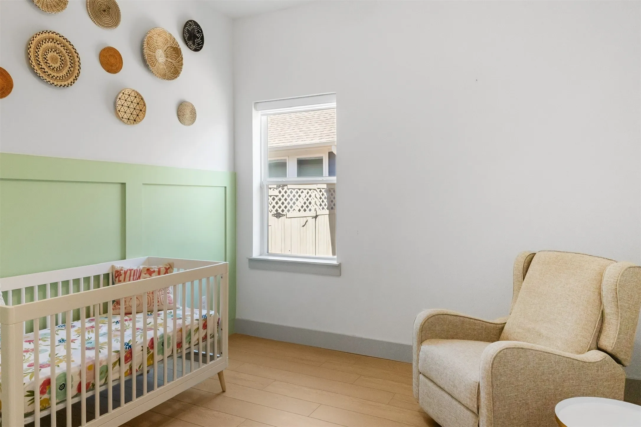 Recessed window, wood-finish flooring, and a two-tone wall treatment with lower panel detailing