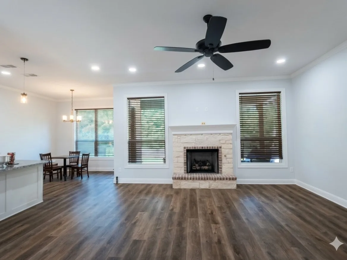 Stone-faced fireplace with brick hearth, wood-finish flooring, recessed lighting, and a ceiling fan