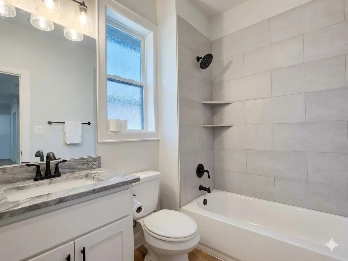 White vanity with a stone-finish countertop, undermount sink, and matte black faucet