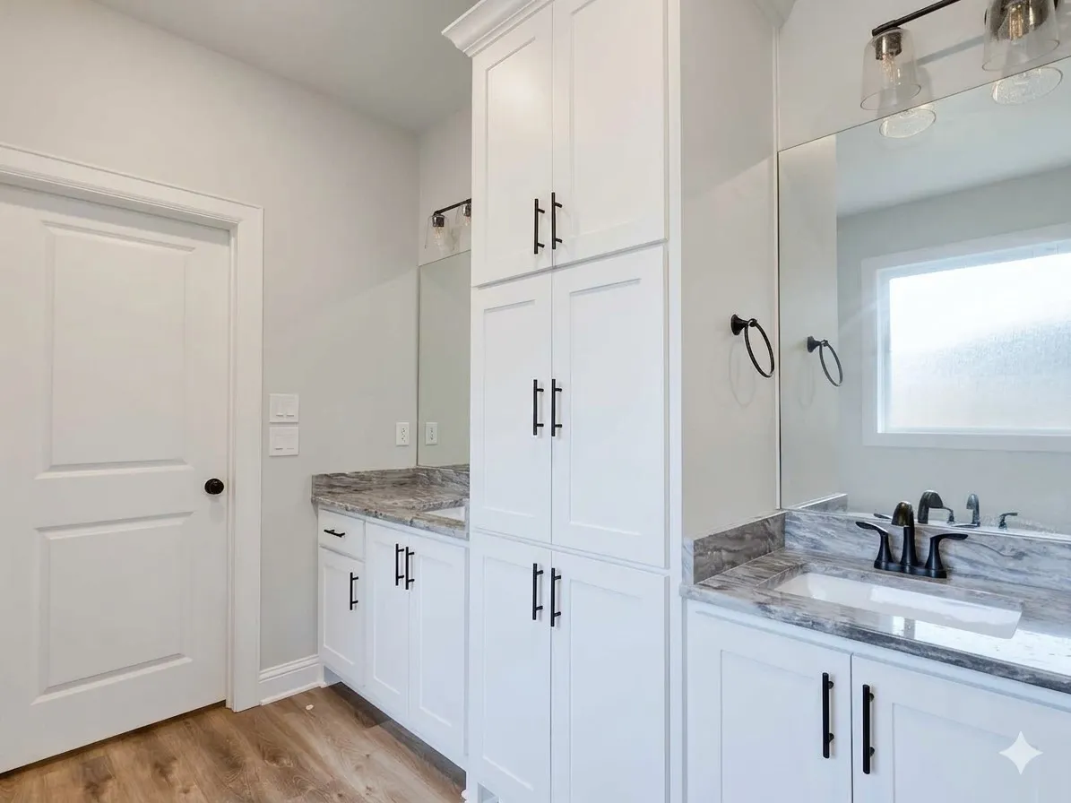 White cabinetry with matte black hardware, dual vanity with undermount sinks, stone countertops, and wood-finish flooring