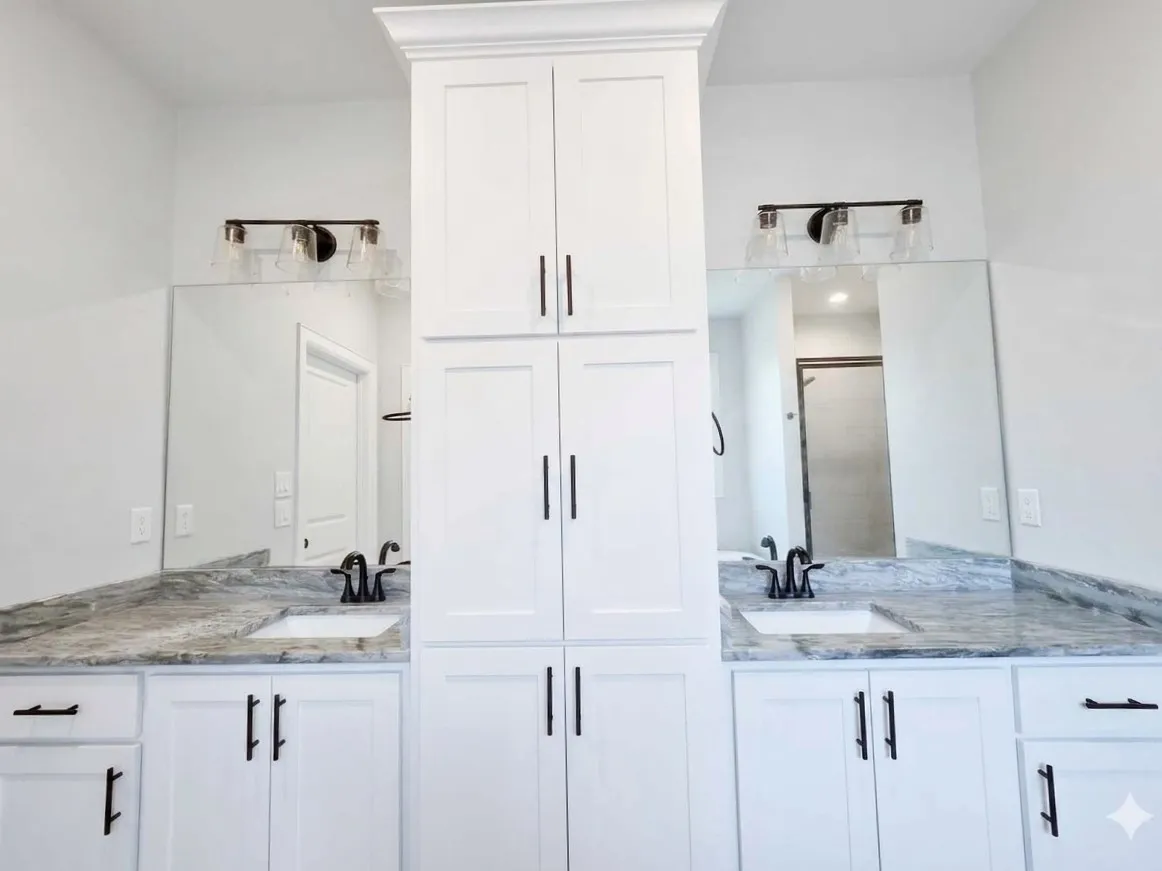 Dual vanity with white cabinetry and dark hardware