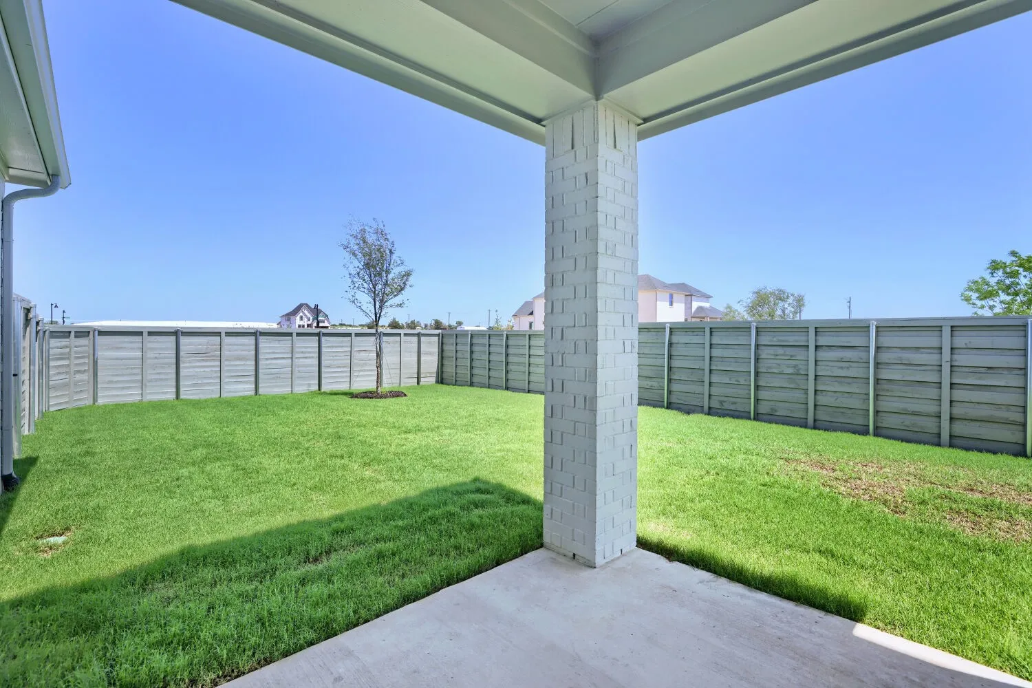 Covered patio featuring a concrete slab and painted brick column