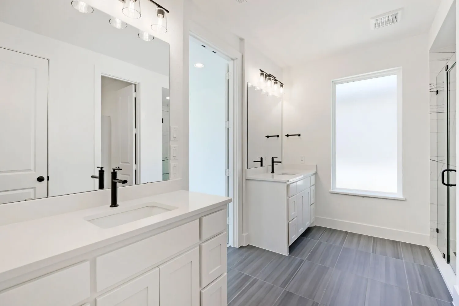 Dual white vanities with integrated sinks, quartz countertops, and matte black fixtures