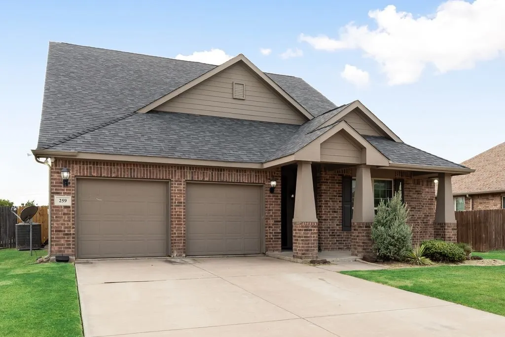 Brick exterior with a covered entry, two-car garage, and concrete driveway