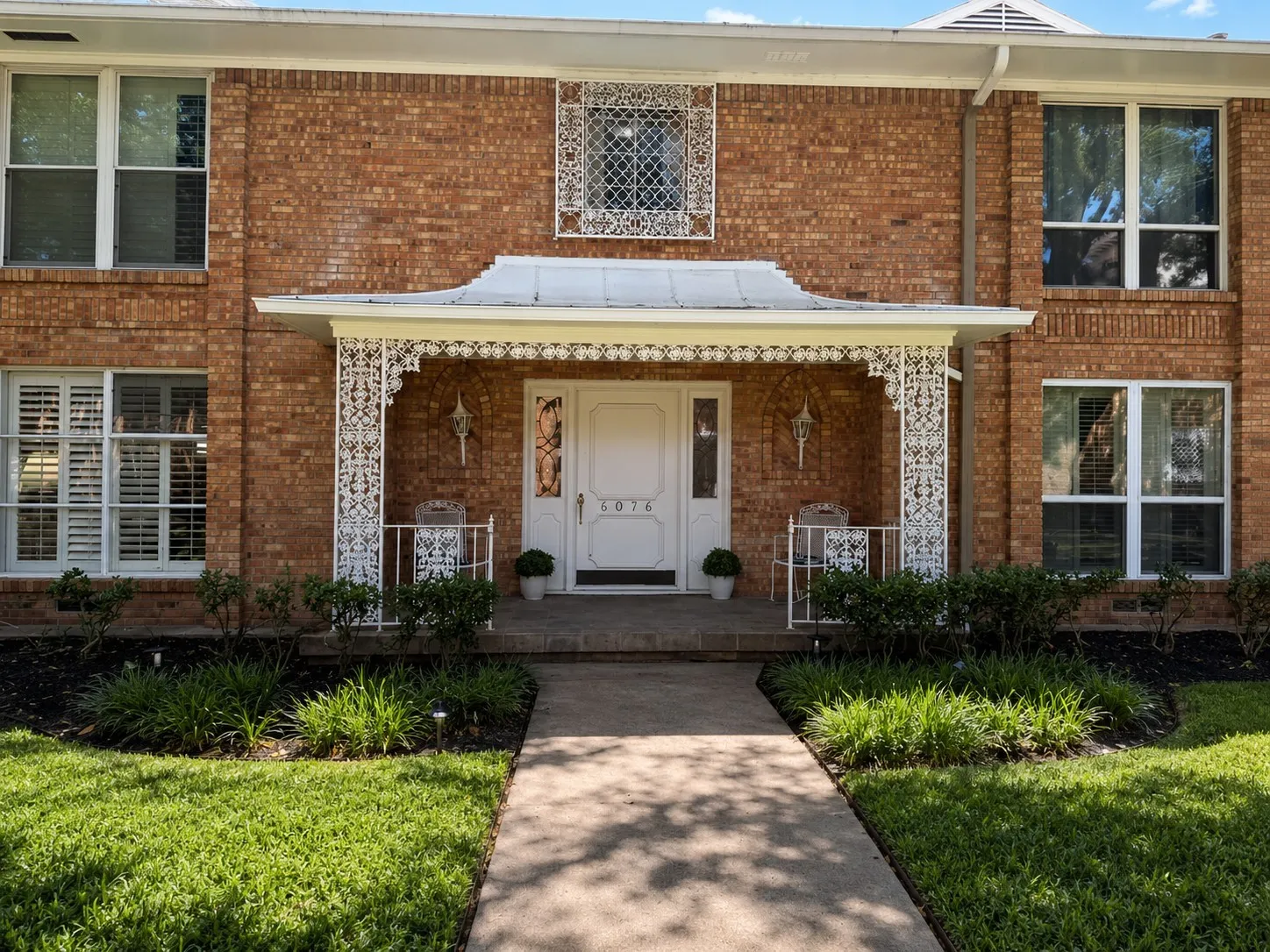 WELCOME TO 6078: A charming covered entrance framed by classic brick, distinctive architectural details and mature landscaping creates a warm welcome to this established Preston Hollow residence.