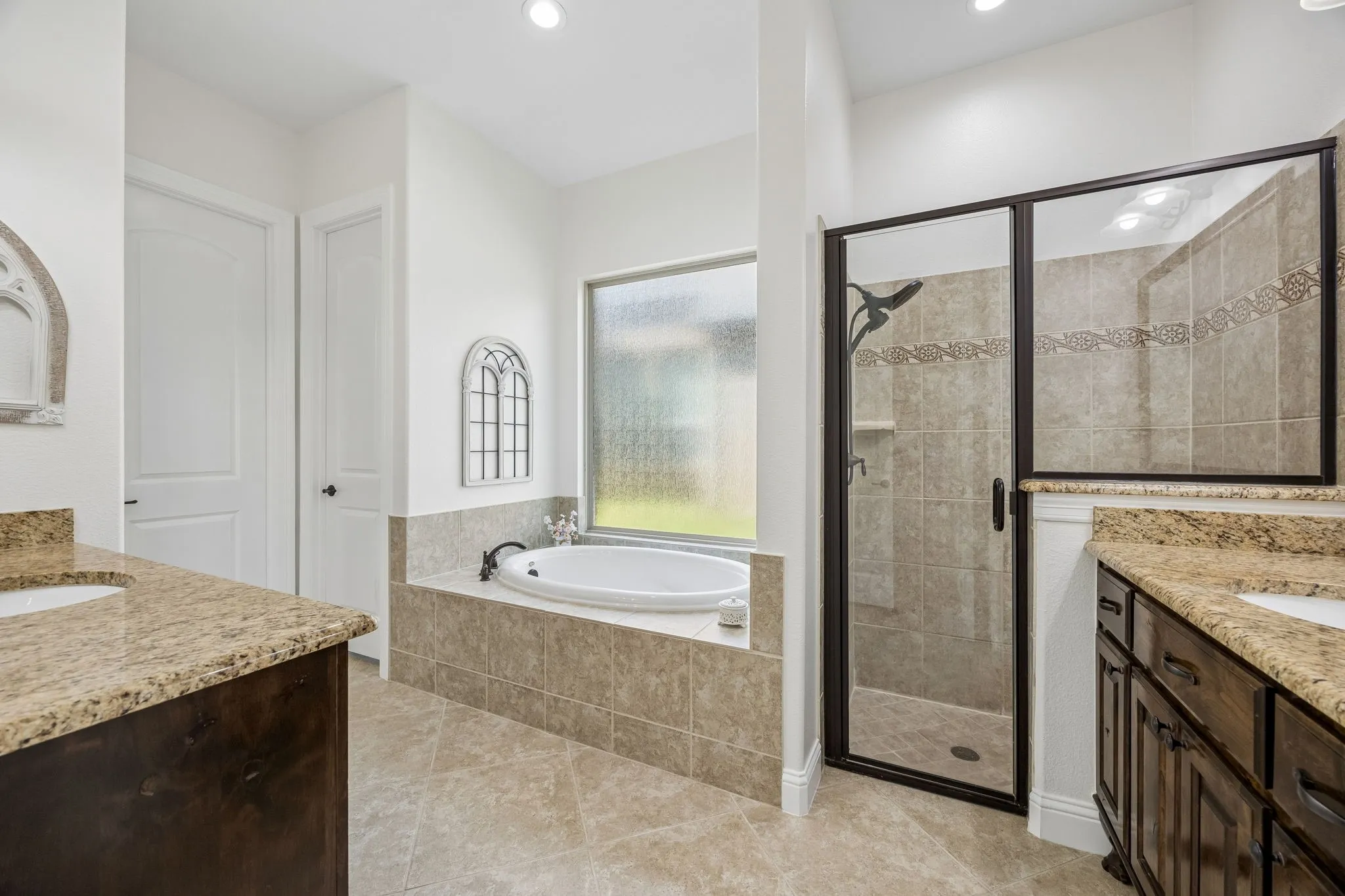 Granite counters, tile floor, walk in tile shower, two sinks, and garden tub.