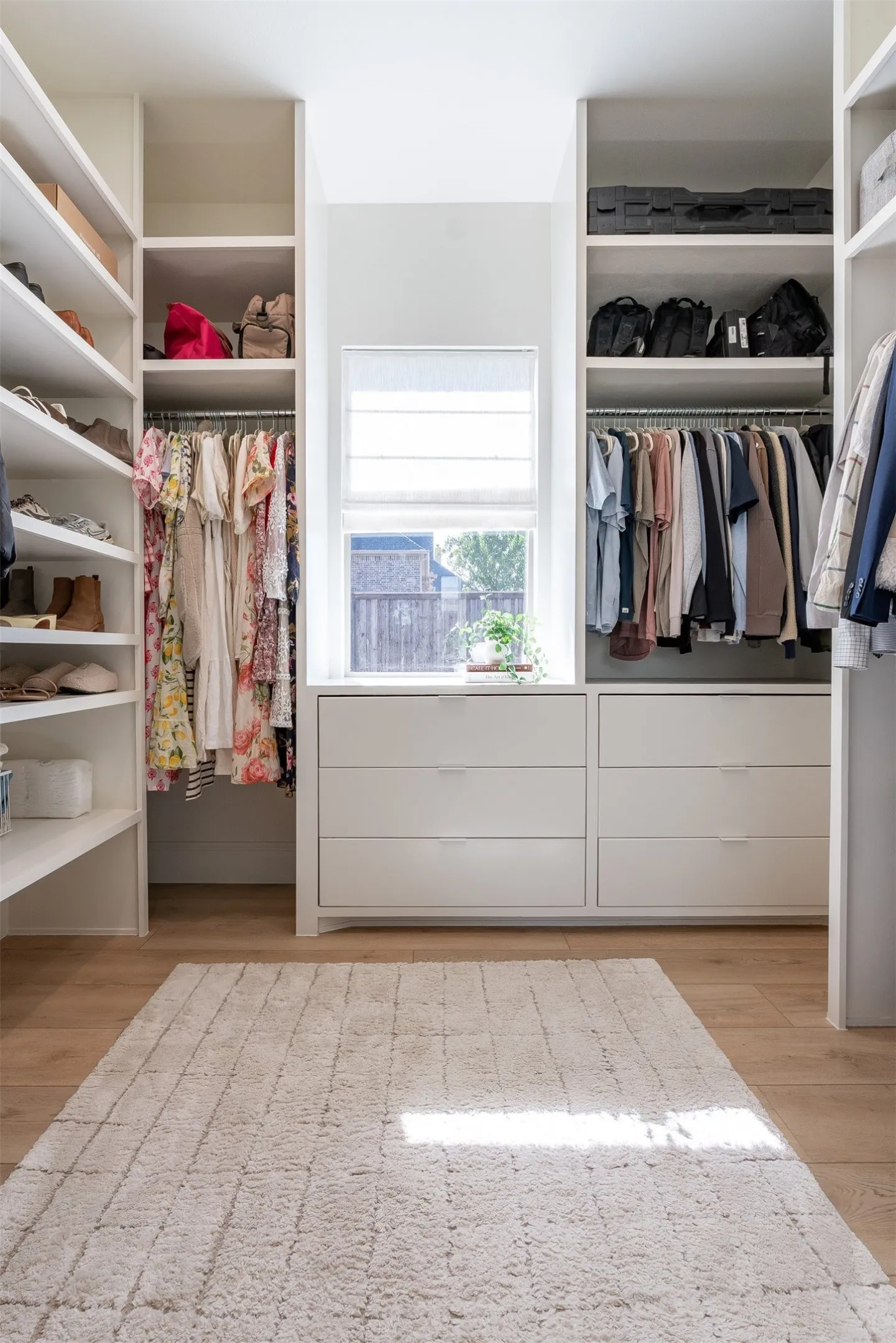 Built-in custom cabinetry, integrated shelving, and central window with privacy shade