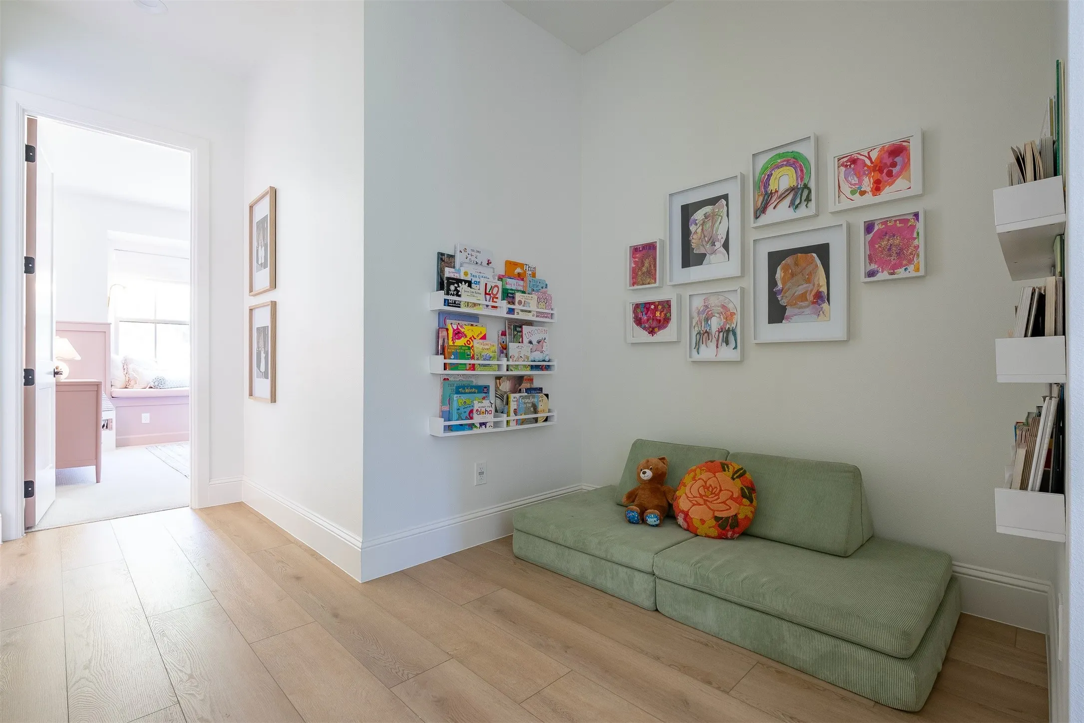 Wood-finish flooring, white baseboards, and built-in wall shelving