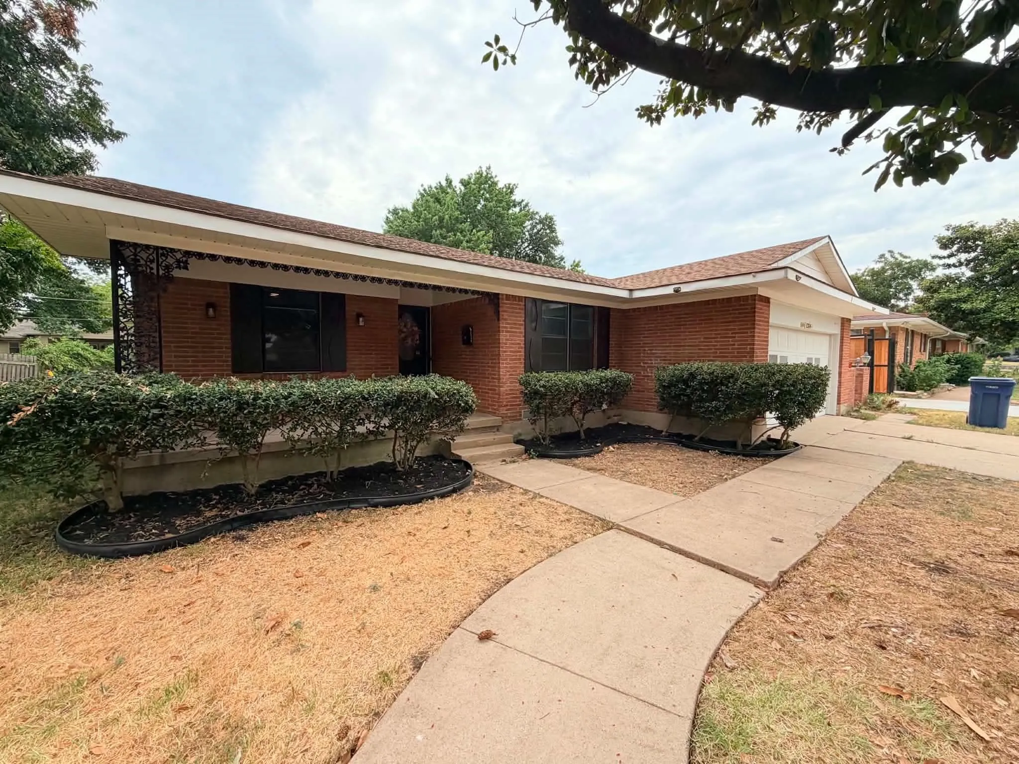 Brick exterior with a covered porch featuring decorative metal accents