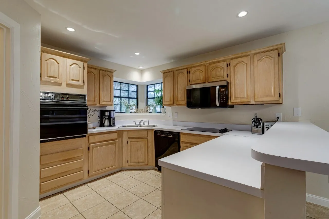 Kitchen featuring light wood cabinetry, recessed lighting, double wall oven, and a built-in microwave