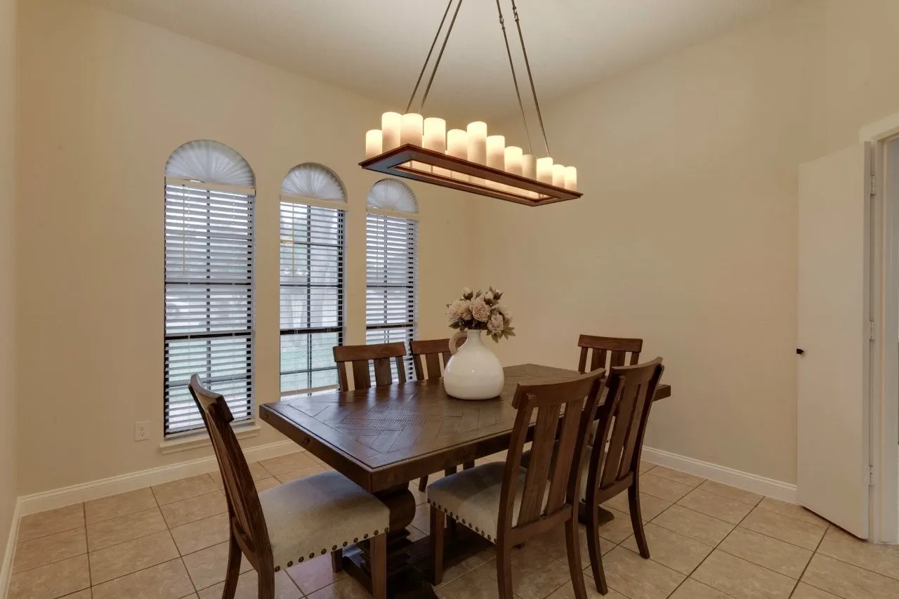 Vaulted ceiling, tile flooring, arched windows, and a rectangular chandelier