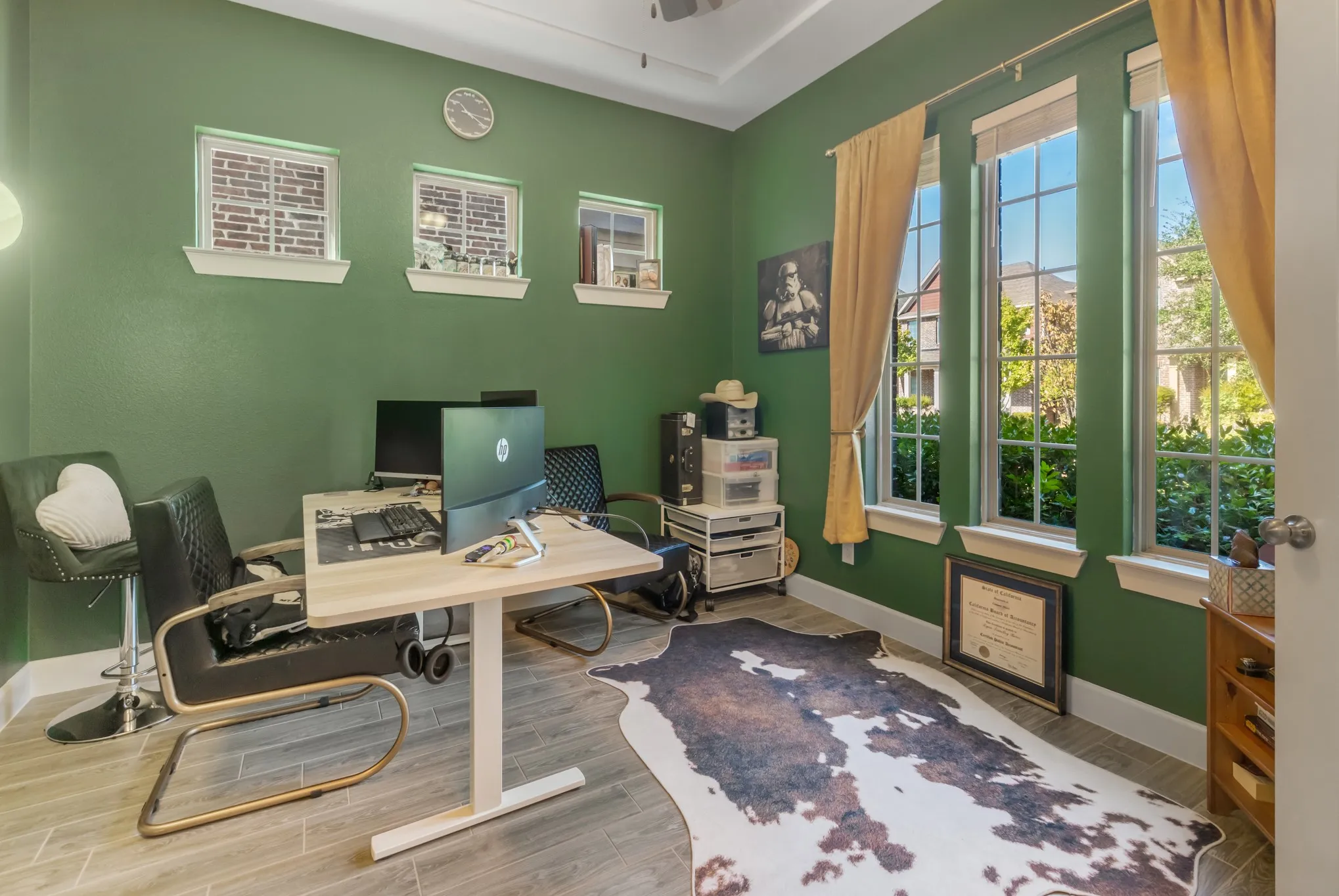 Room featuring three large windows, three transom windows, tray ceiling, recessed lighting, and wood-finish flooring