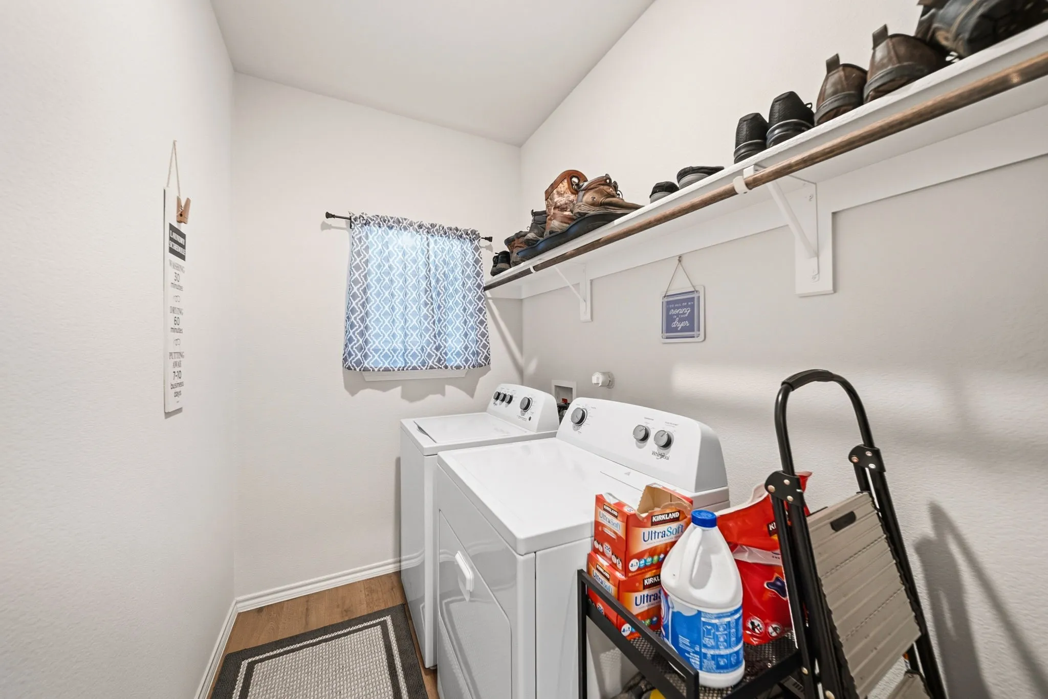 Built-in shelving with hanging rod, window with natural light, and wood-finish flooring