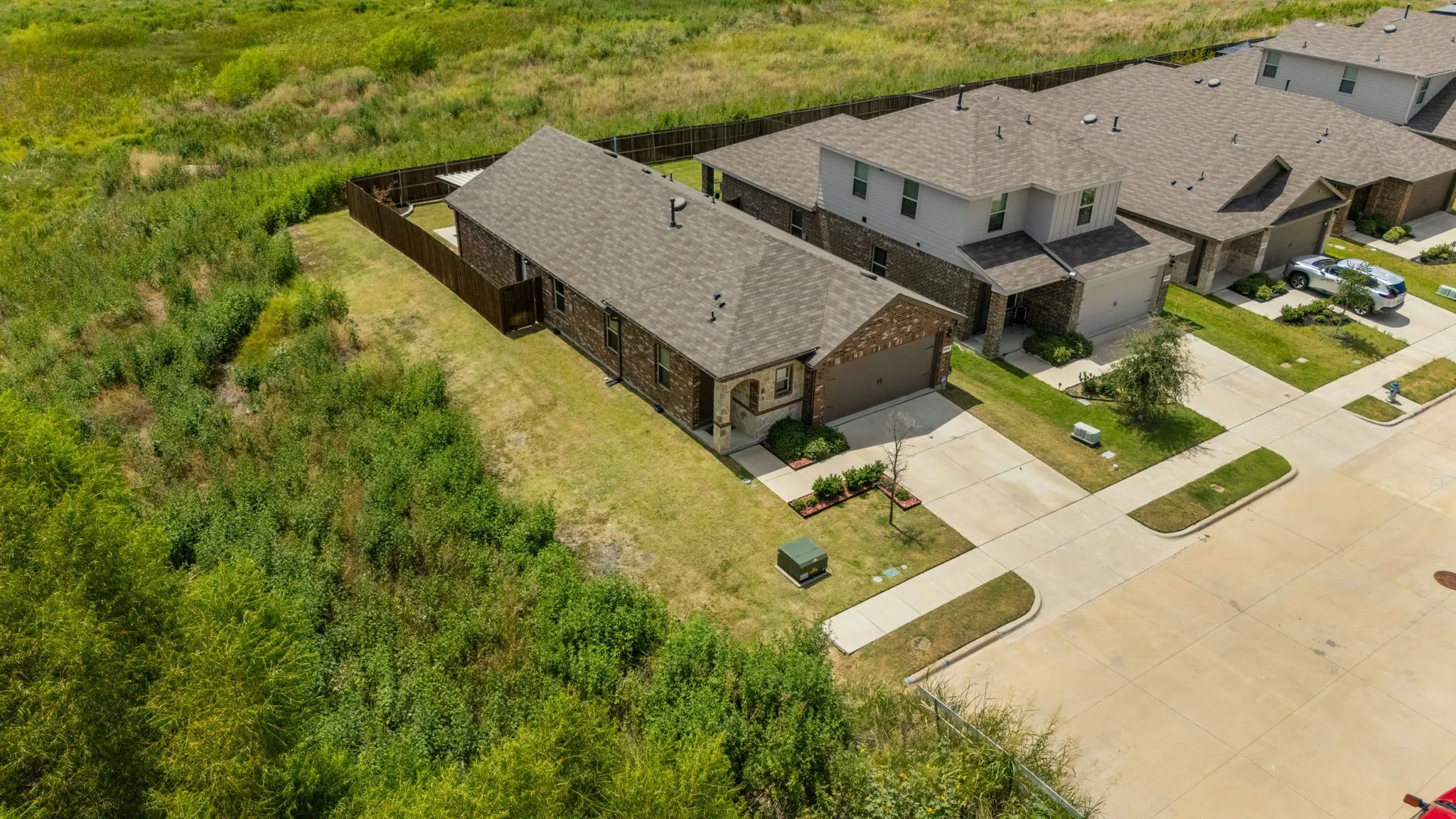 Single-story residence with brick and siding exterior, attached garage, and a fenced backyard