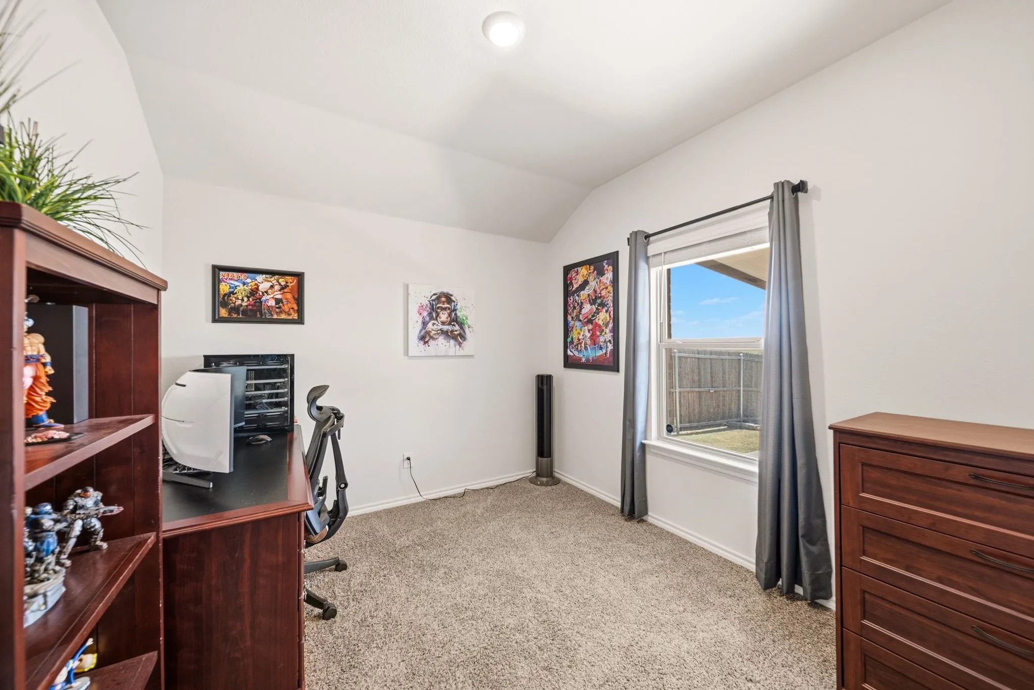 Carpeted flooring, vaulted ceiling, and a single window with a backyard view