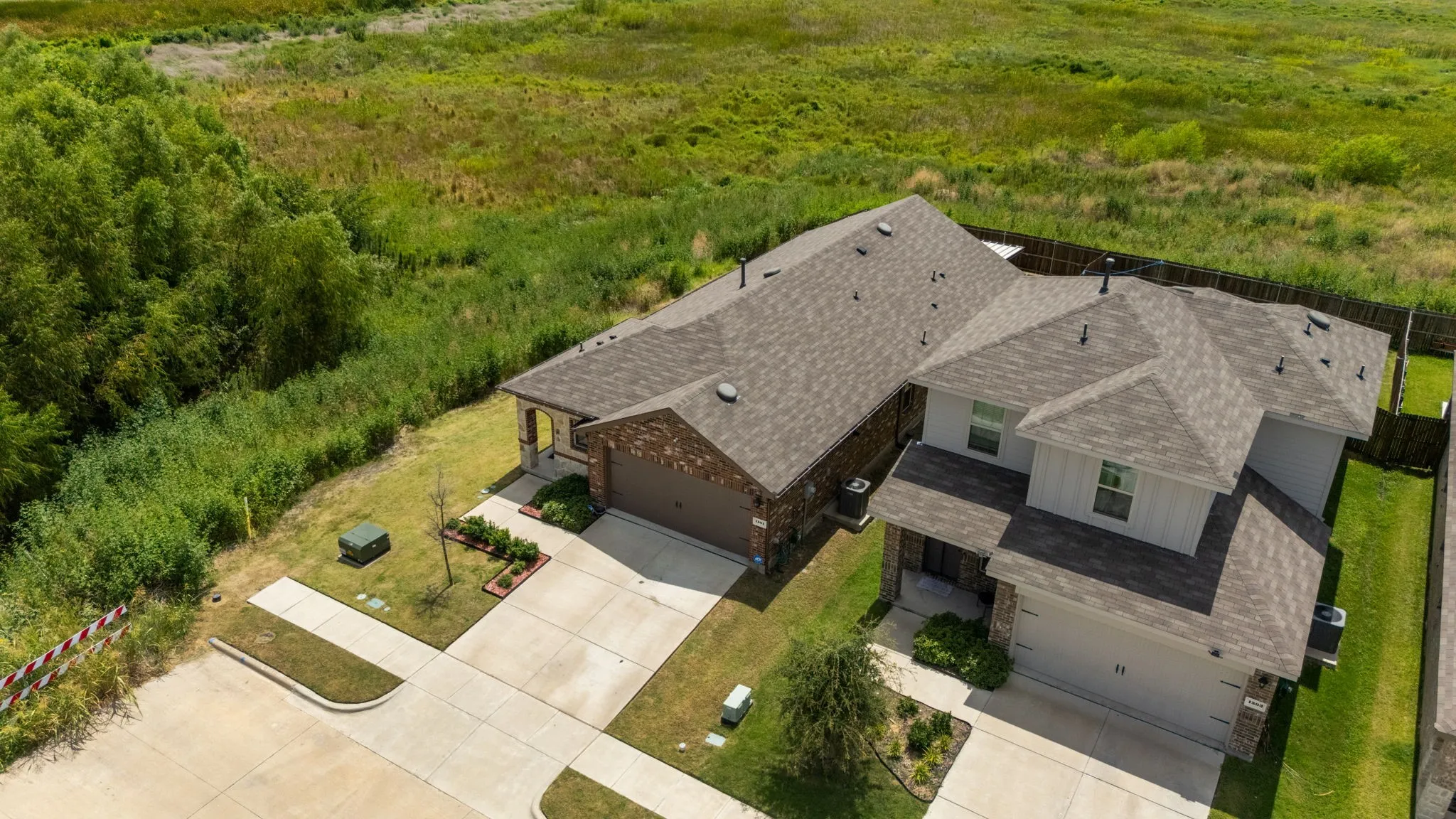 Contemporary residence featuring a two-car garage, brick facade, and a shingle roof
